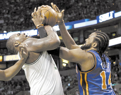 IT’S ON: New York Knicks forward Ronny Turiaf, right, and Boston Celtics forward Glen Davis fight for the ball during the second quarter in Game 1 of a first-round NBA playoff series Sunday in Boston.