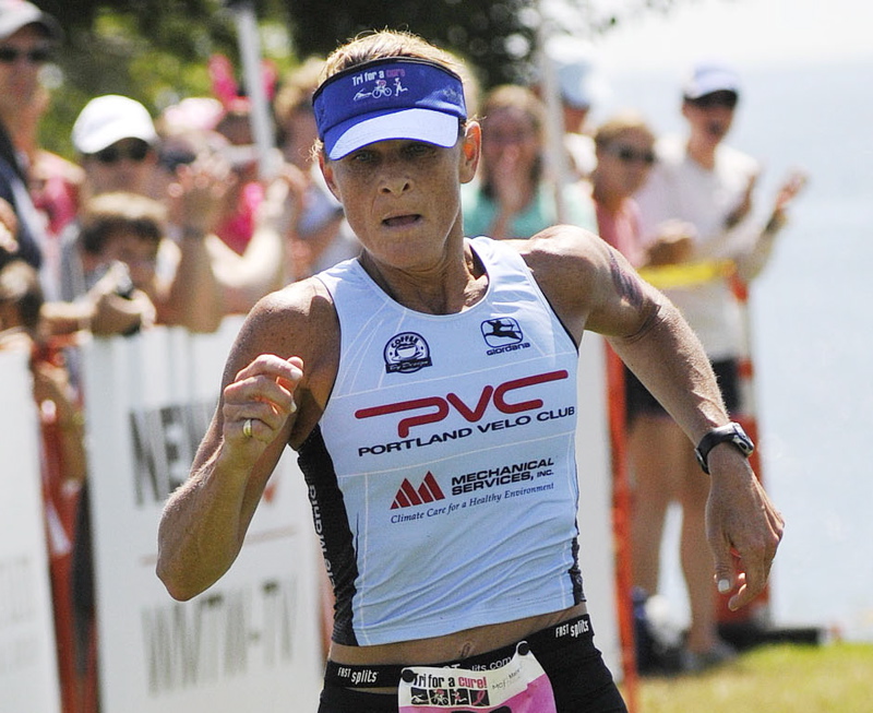 Anne Wilkinson of Falmouth, a three-time winner of Maine Cancer Foundation's Tri for a Cure triathalon crosses the finish line first today in South Portland.