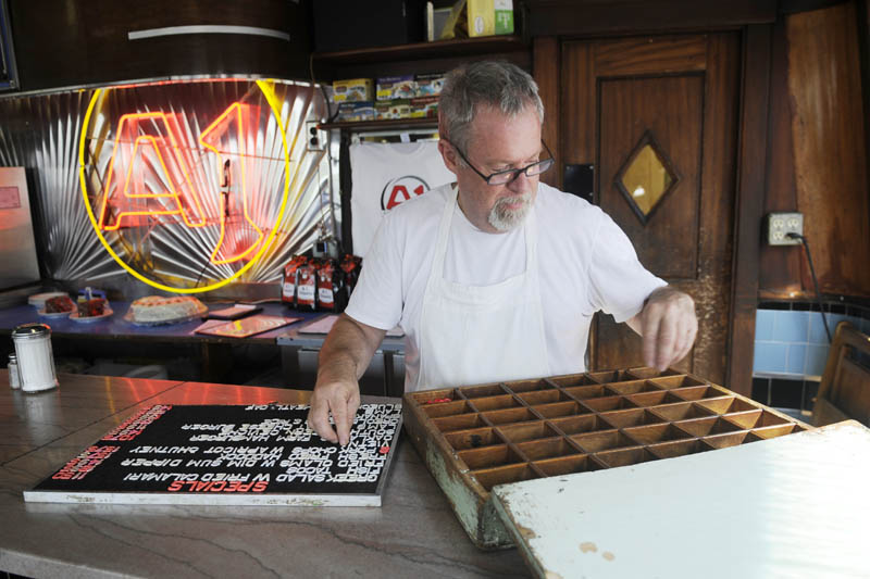 SO, WHAT’S FOR DINNER? A1 Diner proprietor Mike Giberson places letters on a board with dinner specials Wednesday at the Bridge Street establishment in Gardiner. Giberson said sales dropped off when the recession began at the end of 2008, but added they didn’t hit rock bottom. “Since then, sales have been strong,” Beck said.
