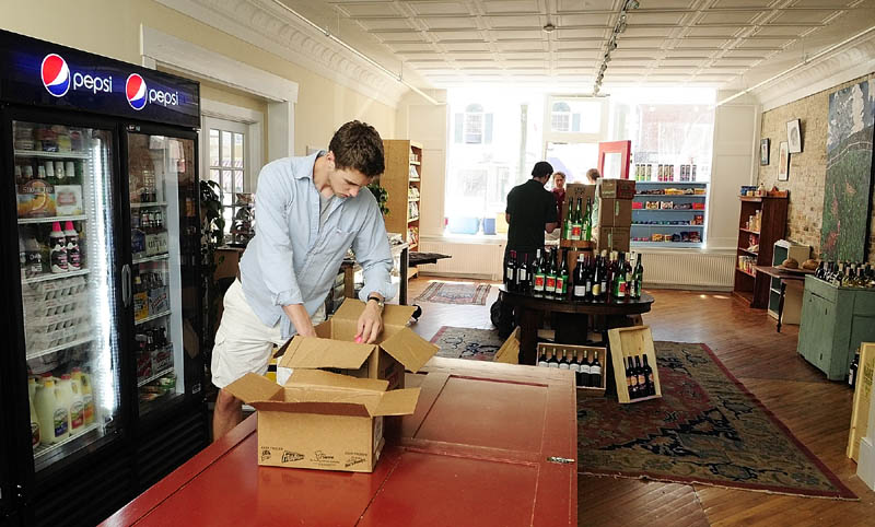 Tim Day stocks shelves on Friday morning at the newly opened store called The Market on Water Street in Hallowell. The store is located in a former antique store next to where Boynton's Market used to be.