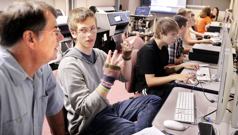 John Hutton, 16, of Greene, confers with University of Maine at Augusta photography professor Jere DeWaters Tuesday at the school's photography studio in Augusta during a class for teenagers as part of the YoUMA program. High school students from across Maine are taking classes at the school this week. Hutton, who is home schooled, was studying digital photography with DeWaters.