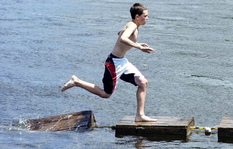 Nathan Vintinner, 14 of Richmond, races across a string of lobster crates floating in the Kennebec River on Saturday during Richmond Days events at Fort Richmond Waterfront Park.