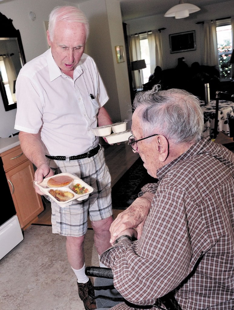 FRESH AND LOCAL: Meals for Wheels driver Gil Pelletier, left, delivers food to Thaddy Gondela in Waterville. Spectrum Generations in central Maine is preparing a new program this fall that incorporates all fresh, nutritious local foods into its Meals on Wheels and community center dining services for the elderly.