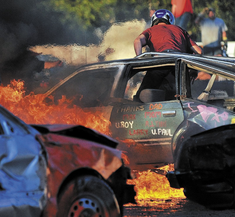 TRIAL BY FIRE: Mike Pellotte leaps from his vehicle in the first heat of the Skowhegan State Fair annual demolition derby in Skowhegan on Aug. 12.