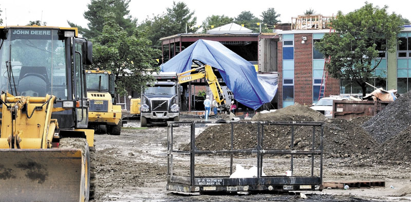 HOME STRETCH: Workers can be seen on Tuesday at the entrance of Waterville Senior High School, where extensive renovations continue both inside and on the school grounds. Some parents have expressed concern that the work will not be finished for the Aug. 29 start of the new school year.