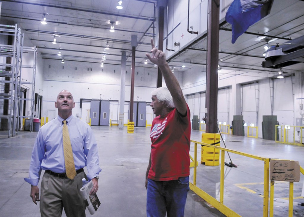 TOUR: Nick Alberding, managing partner and an owner of Pine State Trading, left, gets a tour Monday through the refrigerated storage at the former Associated Grocers warehouse from former AG employee Tom Doucette before an auction for AG's buildings in Gardiner. Camden National Corporation, which held a bank note on the property, made the highest bid.