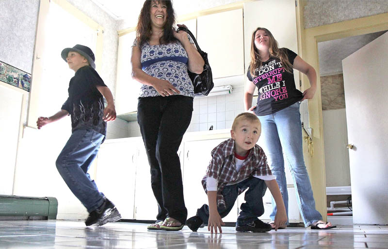 Tracey Bragdon and her three children Keatin, left, Keon, center, and Kaylynn, right, look over their new duplex apartment Thursday. The family lost their home on Oak Street in a fire on Tuesday.