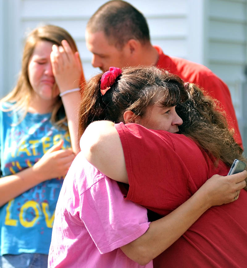 Staff photo by Michael G. Seamans Tracy Bragdon, front left, owner of the Oak Street home destroyed by fire Tuesday morning is consoled by a friend as Forty firefighters from four agencies, Waterville, Winslow, Fairfield and Oakland Fire Departments battle the blaze. No injuries were reported.