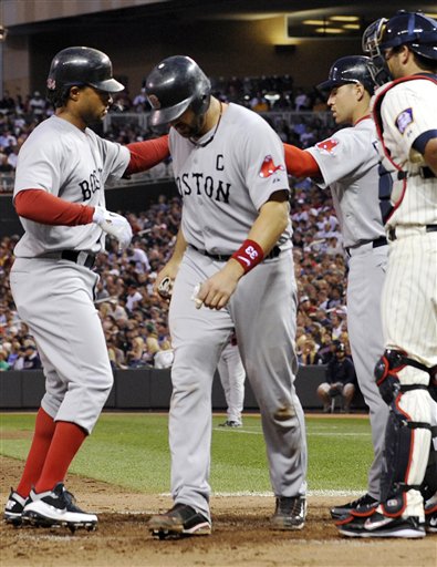 Boston's Darnell McDonald, left, high fives on-deck batter Jacob Ellsbury, second from right, after driving in Jason Varitek, center, with a two-run home run off Minnesota's Francisco Liriano in the fifth inning Tuesday in Minneapolis. At right is Twins catcher Drew Butera.