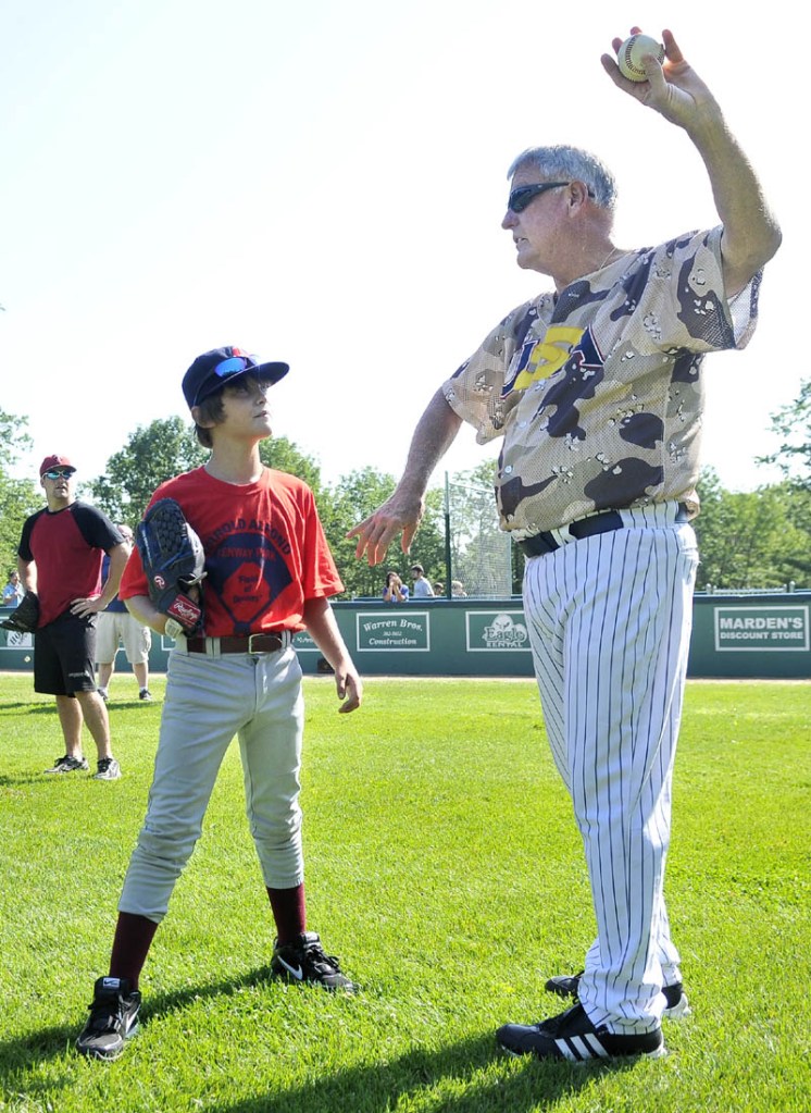TEACHING THE GAME: Former Major League Baseball pitcher Tommy John offers some pitching tips to Wyatt Viles, 10, of Strong, during a baseball academy Monday morning at Harold Alfond Fenway Park in Oakland. John, famous for the surgery performed on his left elbow, pitched 26 seasons in the majors.