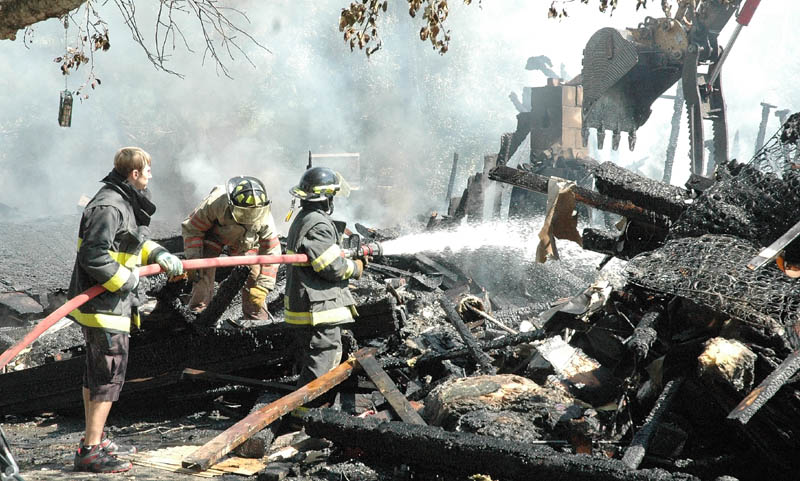 Members of the Athens Volunteer Fire Department soak what’s left of the home of Dwayne and Mary Brown on Valley Road in West Athens on Thursday morning. The family of five lost three dogs and all their belongings. They were not insured.