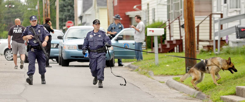 A Maine State Police K-9 unit searches along Lasalle Street for the man who robbed the Winslow Community Federal Credit Union on nearby Monument Street on Thursday morning.