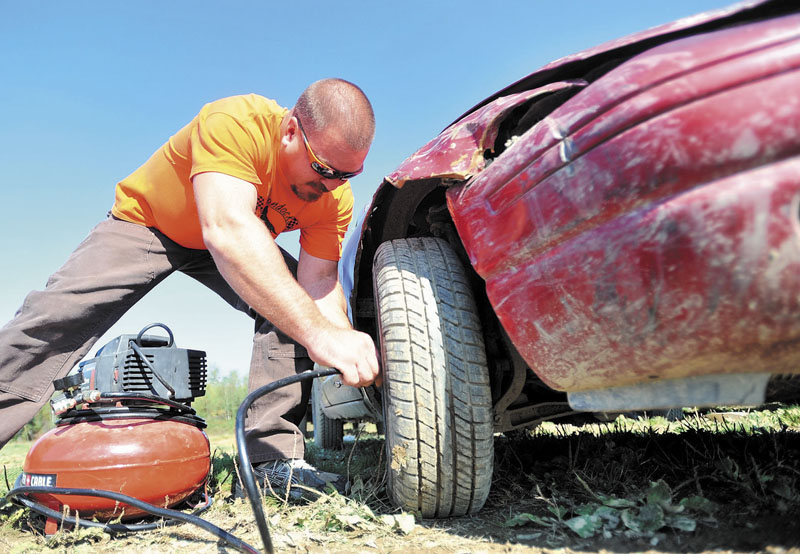 RACE READY: Chuck Wallace checks the tire pressure on his late-model Dodge before the Enduro heat at Boondocks Raceway in Skowhegan on Saturday.