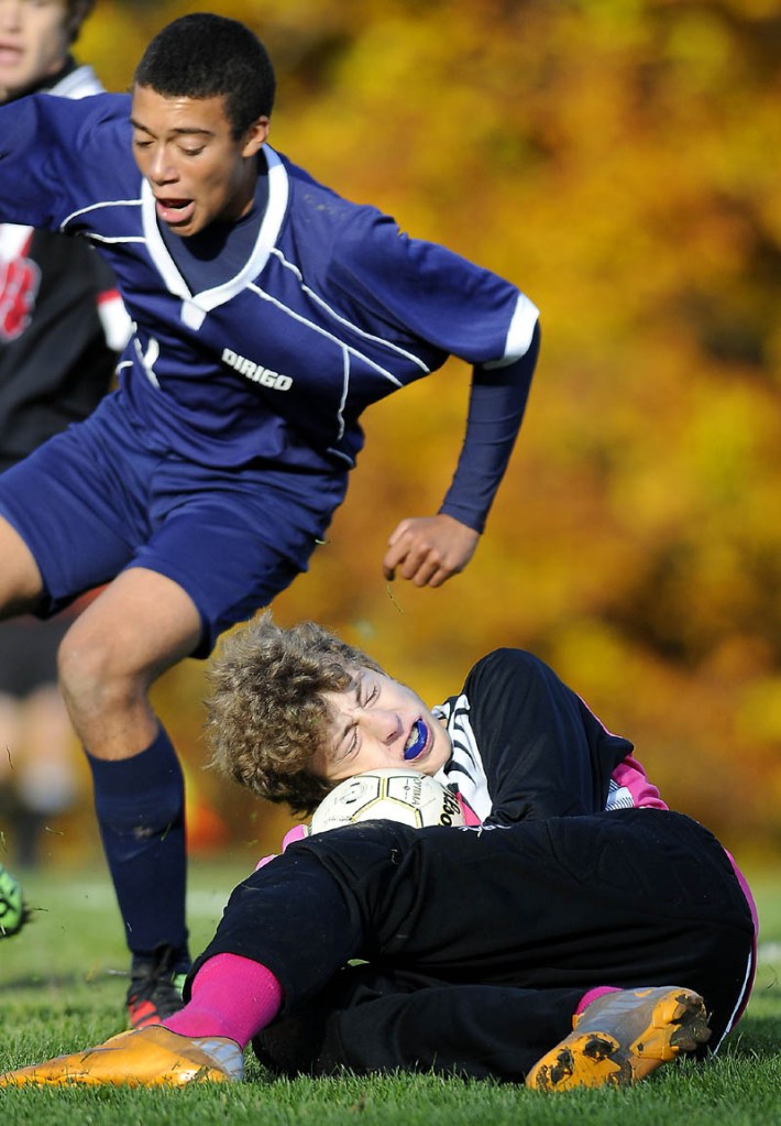 DUCK AND COVER: Hall-Dale High School goalkeeper Sam Shepherd covers a shot on net by Dirigo High School's Trevor Statham during a Western Class C soccer quarterfinal Wednesday in Farmingdale.