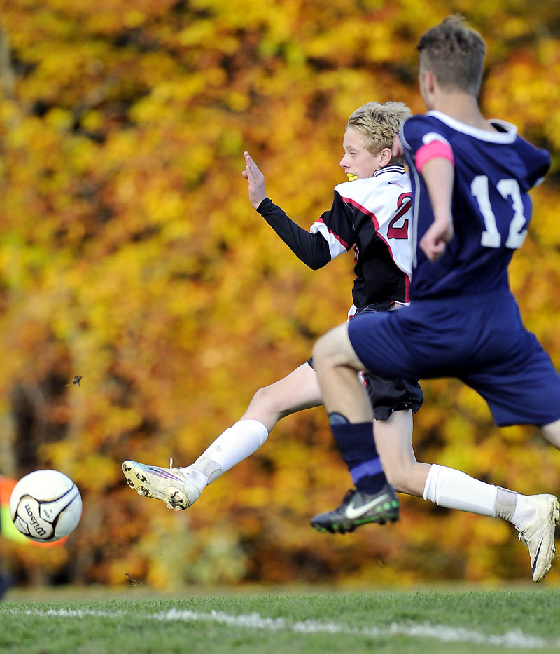 Hall-Dale High School Nat Crocker, left, shoots the game winning goal Wednesday past Dirigo High School's Jeremy Briggs during a Western Class C quarterfinal soccer match Wednesday in Farmingdale.