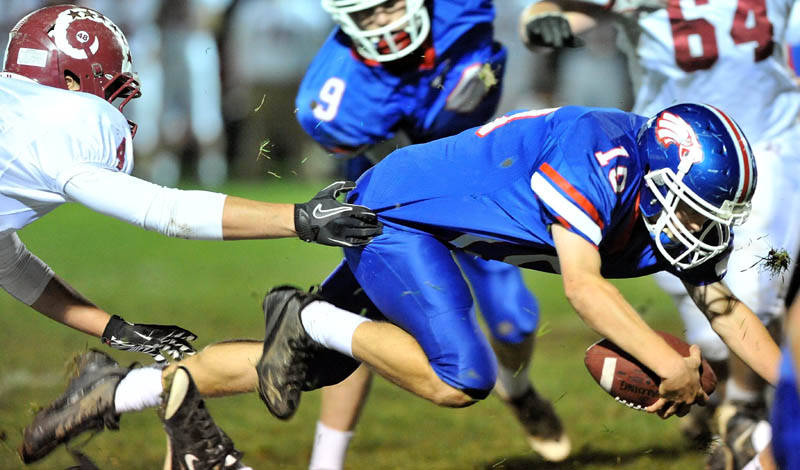 GOING FOR MORE: Messalonskee High School quarterback Travis St. Pierre dives for a first down in the first quarter against Bangor High School on Friday in Oakland.