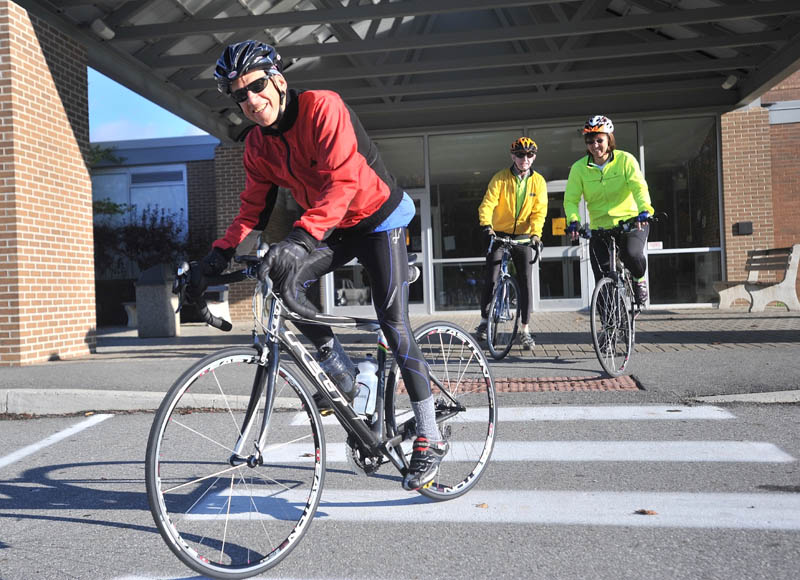 PEDAL POWER: Jim Good, front left, Brian Bowker, back center, and Denise Crowell, back right, leave Winslow High School on their road bicycles Saturday morning as part of a scholarship fundraiser.