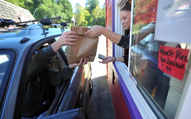 FAST FOOD: Danny McKinnis, left, picks up his order from Erin Falconer at the Red Barn drive-through in Winslow Thursday afternoon.