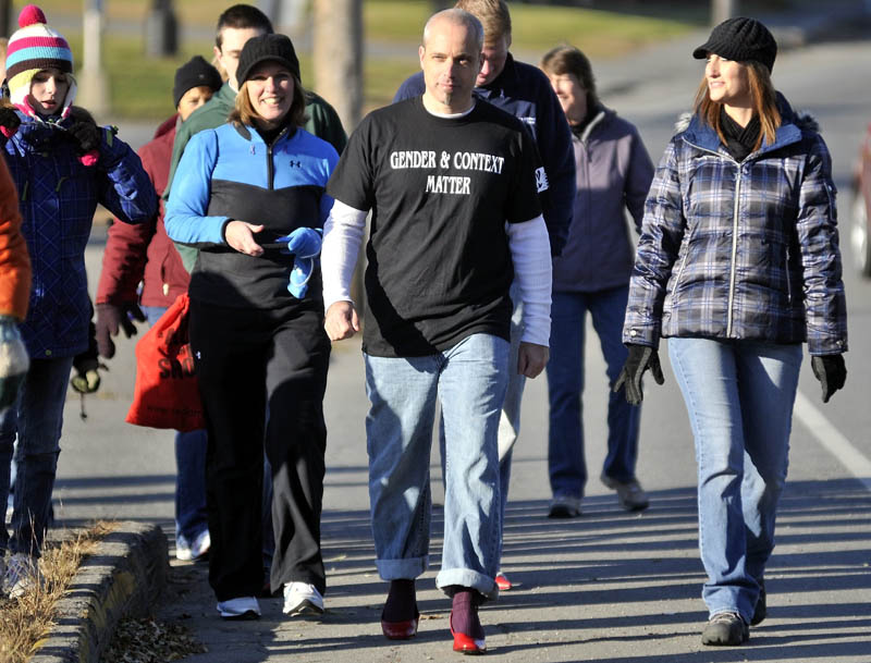 HIGH HEELS, RAISED AWARENESS: Jon Heath, center, leads the Walk a Mile in her Shoes event in red high heels in Skowhegan Saturday morning. Walk a Mile in Her Shoes was organized by the Somerset Domestic Violence Task Force to raise awareness about domestic violence.