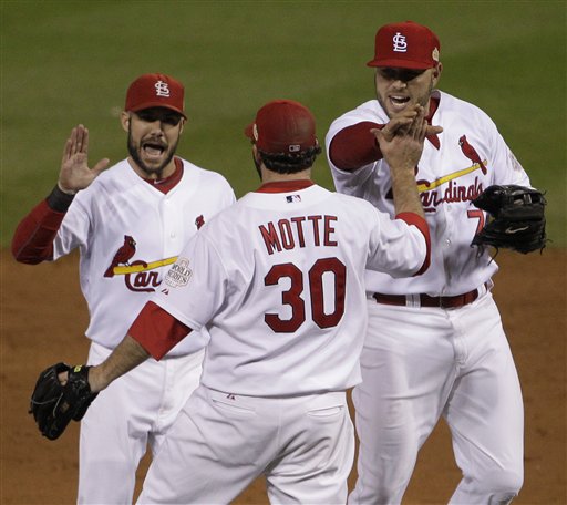 St. Louis Cardinals' Nick Punto, Jason Motte (30) and Matt Holliday (7) celebrate after the ninth inning of Game 1 of baseball's World Series against the Texas Rangers Wednesday, Oct. 19, 2011, in St. Louis. The Cardinals won 3-2 to take a 1-0 lead in the series. (AP Photo/Paul Sancya)