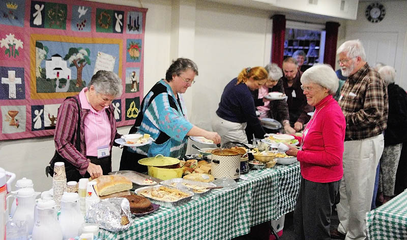 Members of St. Andrews Episcopal Church and the Winthrop Center Friends Church get together for a potluck meal at St. Andrews in Readfield on Friday evening. A quilt showing their soon-to-be former building hangs in the background.