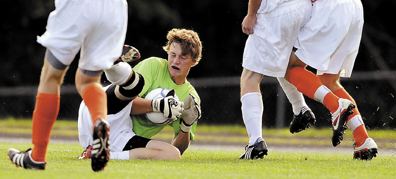 HOLDING ON: Erskine Academy goalkeeper Ryan Pulver collects a shot on net during a game against Brunswick High School in South China.