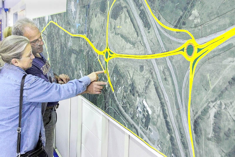 MAPPING OUT CHANGE: Evelyn Poulin, left, and Donald Poulin check out a large print of proposed changes to Exit 113 off Interstate 95 on display at a Tuesday night meeting at Gilbert Elementary School in Augusta. The changes for the interchange include two traffic circles.