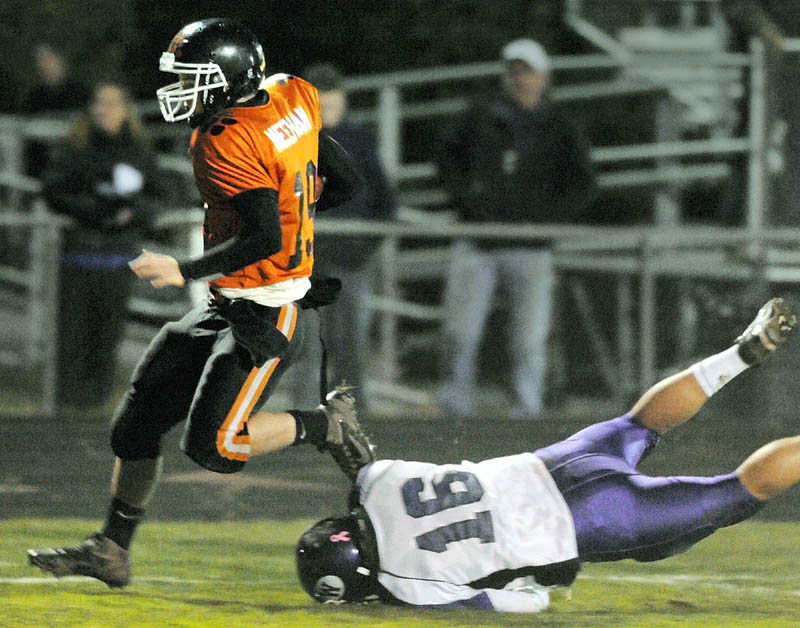 Gardiner quarterback Dennis Meehan, left, leap s away from a diving Waterville defensive back Aaron Saucier on his way to scoring on 32 yard touch down run during a game on Friday at Hoch Field in Gardiner.