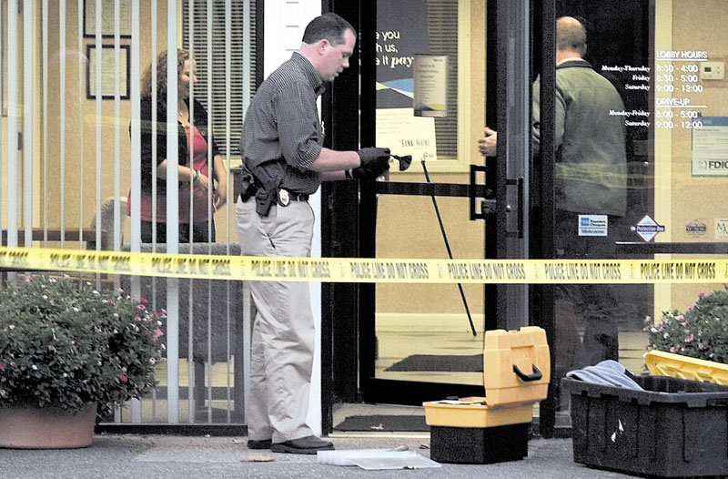 FINGERPRINTING: Waterville police Detective David Caron dusts the door of the Savings Bank of Maine for fingerprints shortly after an armed robbery on Wednesday at the Upper Main Street bank. It was the third bank robbery in eight weeks in Waterville, and the city’s second such robbery in the last 48 hours.