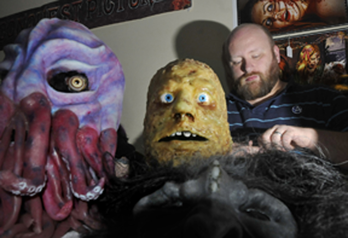 Eric Anderson, of Portland, a special-effects artist, works on straps for his masks during the Coast City Comicon in Portland on Sunday.