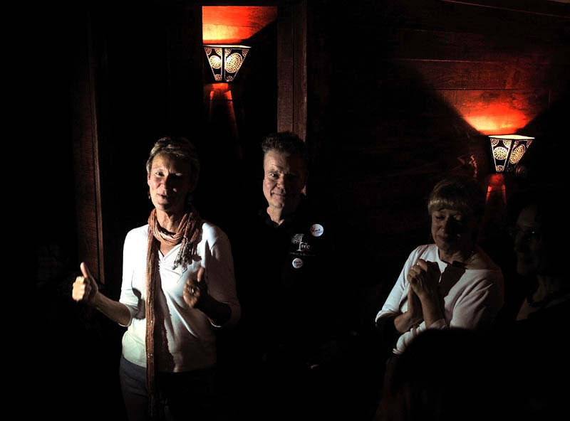 Mayor-elect Karen Heck, left, gives the thumbs-up gesture as she give a speech to supporters at 18 Below Raw Bar in Waterville Tuesday night after winning the mayoral election.