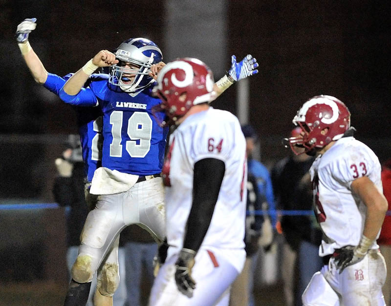 ALL RIGHT: Lawrence High School’s Alex Leathers (19) celebrates with teammate Aaron LeFrance after a touchdown in the second quarter of the Pine Tree Conference Class A championship game Friday night at Keyes Field in Fairfield. The Bulldogs beat the Rams 40-14 to advance to the state title game.