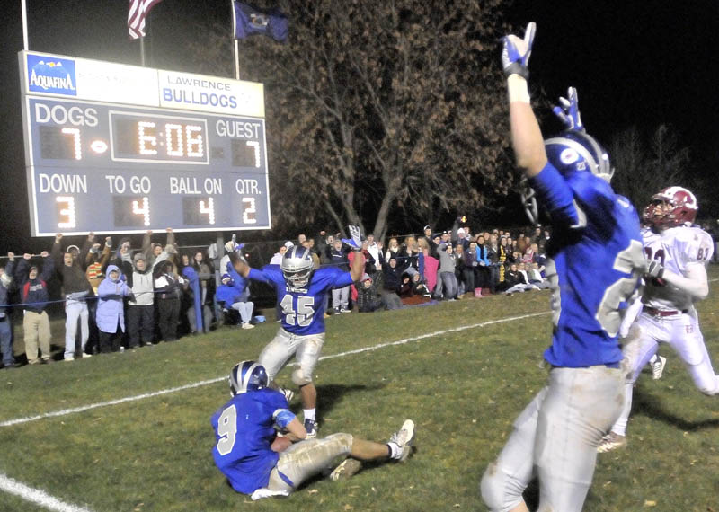 Lawrence High School's Spencer Casey, 9, lands in the endzone after a touchdown catch in the second quarter against Bangor High School at Lawrence High School in Oakland Friday, Nov. 11, 2011. Lawrence teammates Bryant Wade, 45, back center and Aaron LeFrance, 23, right, hold their hands up to signify a touchdown.