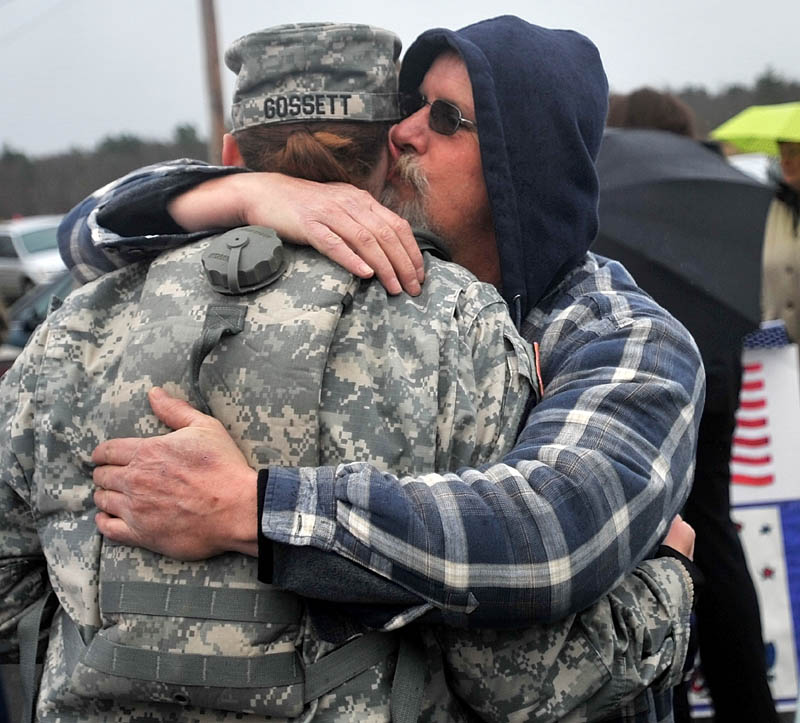 Staff photo by Michael G. Seamans Timothy Grenier, right, hugs and kisses Rita Gossett, after a Veteran's Day ceremony at the Winslow Memorial Park Friday.