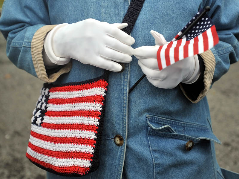 Staff photo by Michael G. Seamans Marie McMahon holds a small flag along with her American flag embroidered bag before the start of the Veteran's Day parade at Head of Falls in Waterville Friday morning.