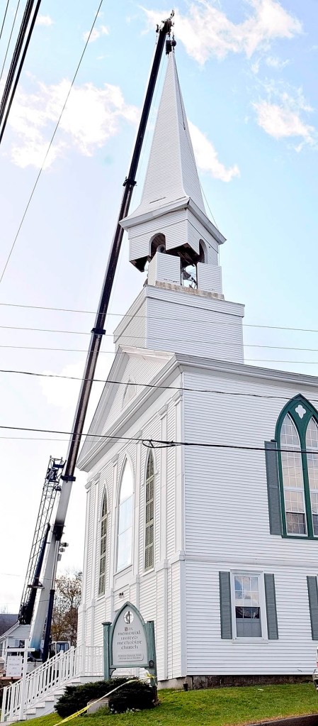STEEPLE PEOPLE: A crane lifts the steeple off Cox Memorial Methodist Church in Hallowell Friday morning. Steeplewright Robert Hanscom and a crew from Cote Crane Services removed the old steeple of the church at the corner of Central and Middle streets. Hanscom was hired to build a replacement, to be installed next year.