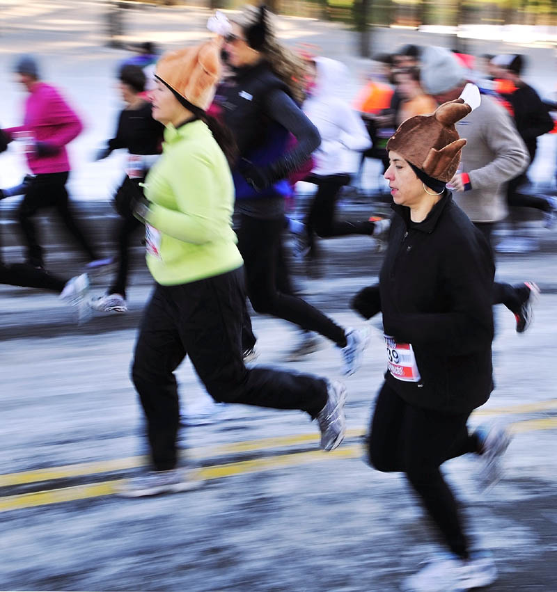 Laura Gosselin, left, and Sarah McGuire, both of South China, wear turkey hats on Thursday morning as they start the Gasping Gobbler 5K Road Race to benefit Cony High School athletics in Augusta