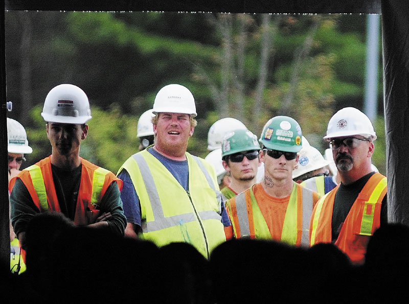 ABOUT READY TO WORK: Construction workers stand outside the tent watching a celebration of groundbreaking event recently held near the site of the new MaineGeneral Medical Center in North Augusta. A live video of the event was streamed to all of MaineGeneral’s worksites. Councilor Darek Grant, chairman of the Eastside Planning Committee, said the city must work closely with MaineGeneral when the hospital relocates to its new complex now under construction in north Augusta.