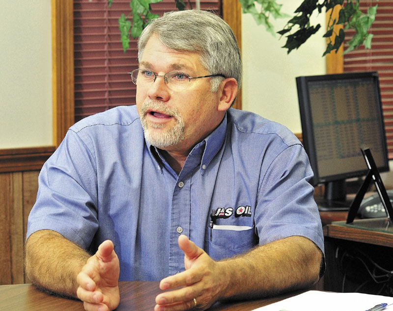 John Babb follows the price of oil on a monitor on his desk at the J&S Oil's headquarters in Manchester.