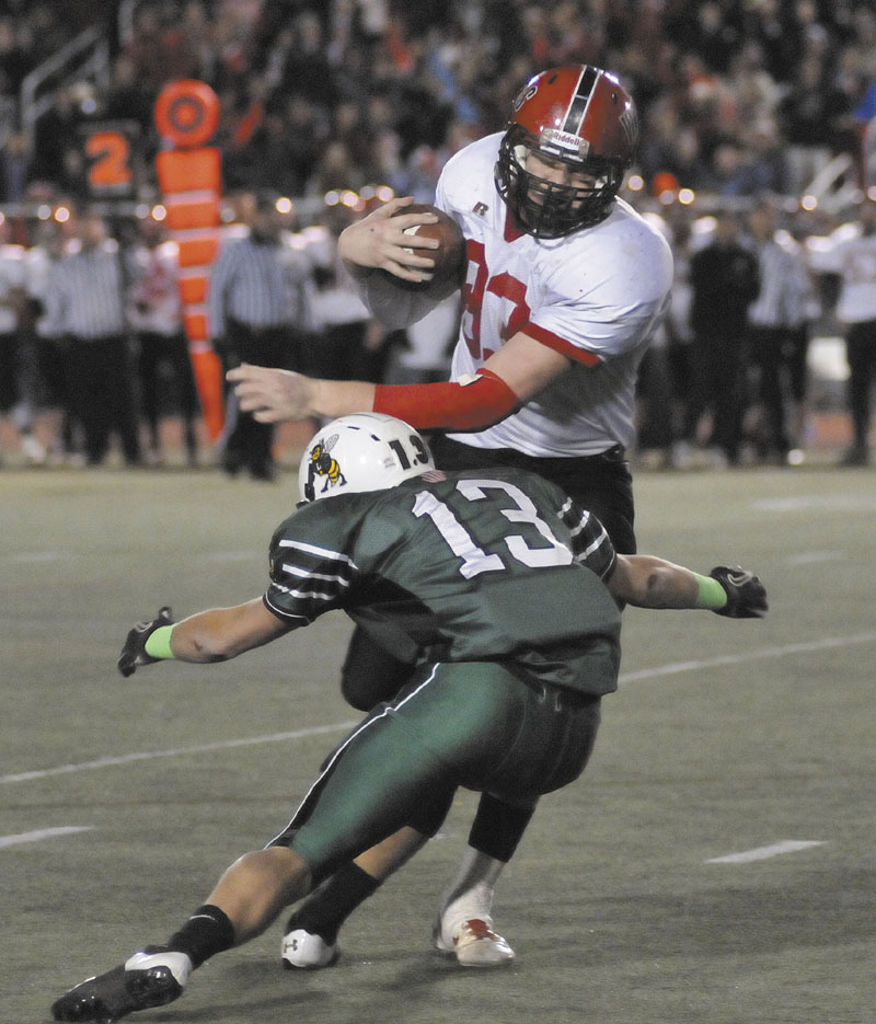 NOT GOING DOWN EASILY: Joshua Ingalls, right, of Wells tries to elude the tackle of Leavitt’s Brian Bedard during the Class B state championship football game Saturday in Portland.