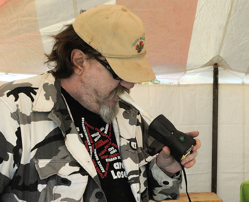 VAPORIZER AT WORK: Chris Kenoyer uses a Happy Vappy vaporizer to inhale marijuana in a tent in the parking lot during the Medical Marijuana Caregivers’ Home Grown Maine trade show Saturday at the Augusta Civic Center.