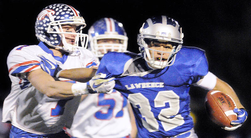 Messalonskee cornerback Sam Dexter, left, snags a hold of Lawrence running back Shaun Carroll Jr. during a Friday night game on Keyes Field in Peter Cooper Stadium in Fairfield.