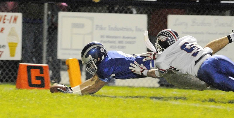 Lawrence's Spencer Carey, left, dives across the goal line as Messalonskee's Gage Landry tries to stop him during a Friday night game on Keyes Field in Peter Cooper Stadium in Fairfield.