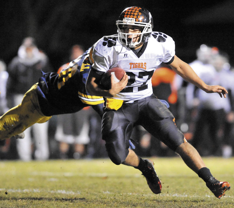 BREAKING AWAY: Gardiner Area High School’s Alonzo Connor, 27, breaks a tackle from Mt. Blue High School’s Brian Durrell in the first quarter Friday night at Kemp Field in Farmington.