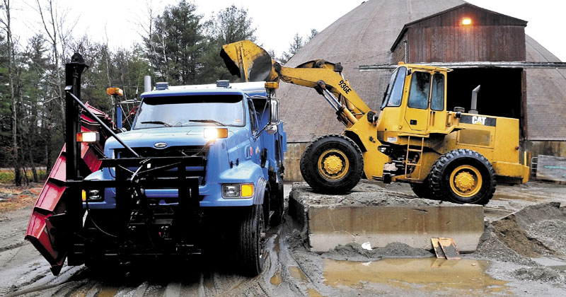 FILL 'ER UP: Willy Marsh loads salt and sand into a Skowhegan Highway Department plow truck on Thursday. The department will be using a road de-icer product called Ice B Gone made of high-sugar beet molasses that is less corrosive on the environment and vehicles.