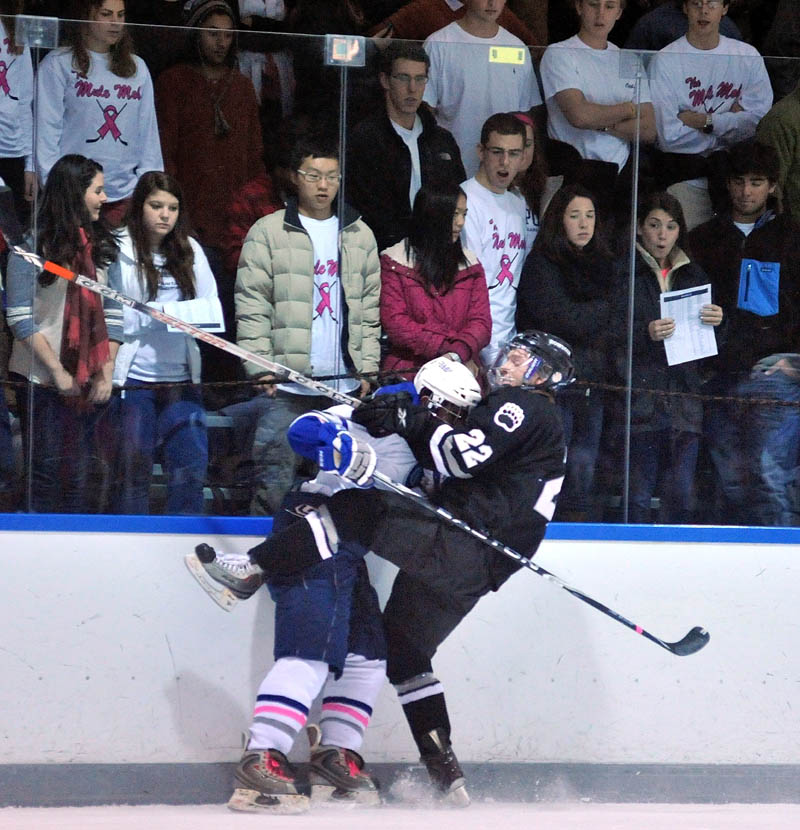 Colby College's Jesse Lehman, left, checks Bowdoin College's Nick Wetzel into the boards during the first period Friday at Alfond Arena in Waterville.