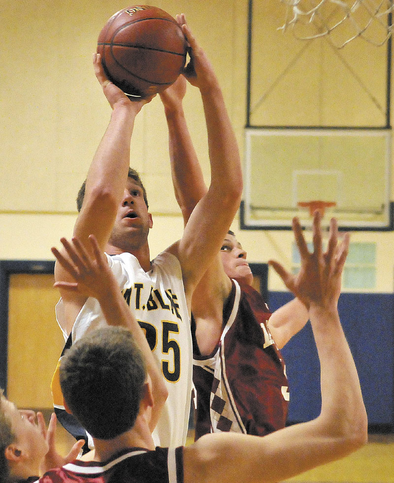 IN TRAFFIC: Mt. Blue High School’s Cam Sennick (25) puts up a shot over Bangor High School defender Ellis Throckmorton in the second quarter Tuesday at Mt. Blue Middle School in Farmington.