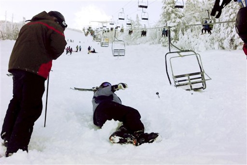 In this Dec. 28, 2010 file photo, a skier comes to help a skier who fell onto the slope after a chair lift derailed at the Sugarloaf ski resort in Carrabassett Valley, Maine. The 35-year-old chairlift that malfunctioned a year ago has now been replaced at a cost of $4 million. (AP Photo/Jack Michaud, File)