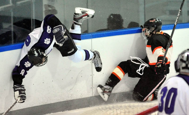 LOOK OUT BELOW: Waterville Senior High School’s Will Bolduc (8) flies head first along the boards after a collision with Brunswick High School’s Clayton Parent, right, in the first period during the Annual Christmas Tournament on Monday at Aflond Arena at Colby College in Waterville.
