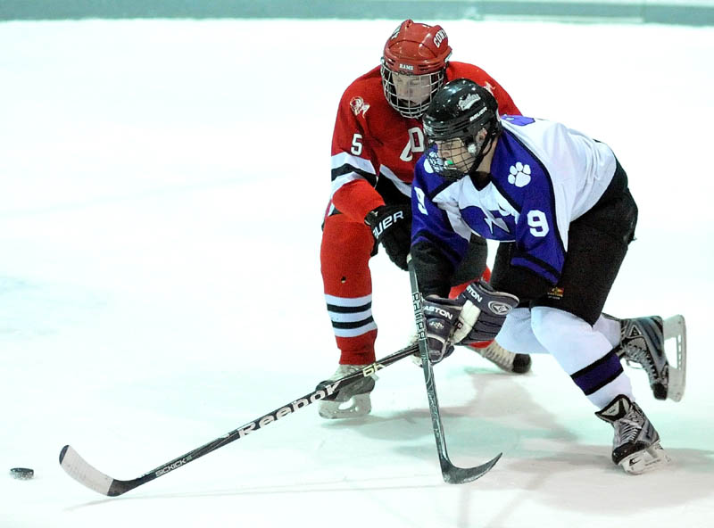 ON THE MOVE: Waterville Senior High School’s J.T. Whitten (9) battles for the puck with Cony High School’s Spencer Buck (5) in the first period of their game Wednesday at Alfond Rink at Colby College.